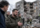 Володимир Зеленски пред разрушен жилищен блок в Украйна на фона на спасителни екипи